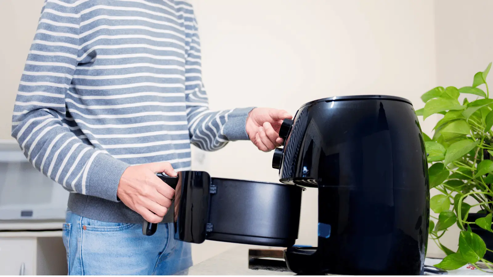 rapaz retirando cesto de uma airfryer limpa